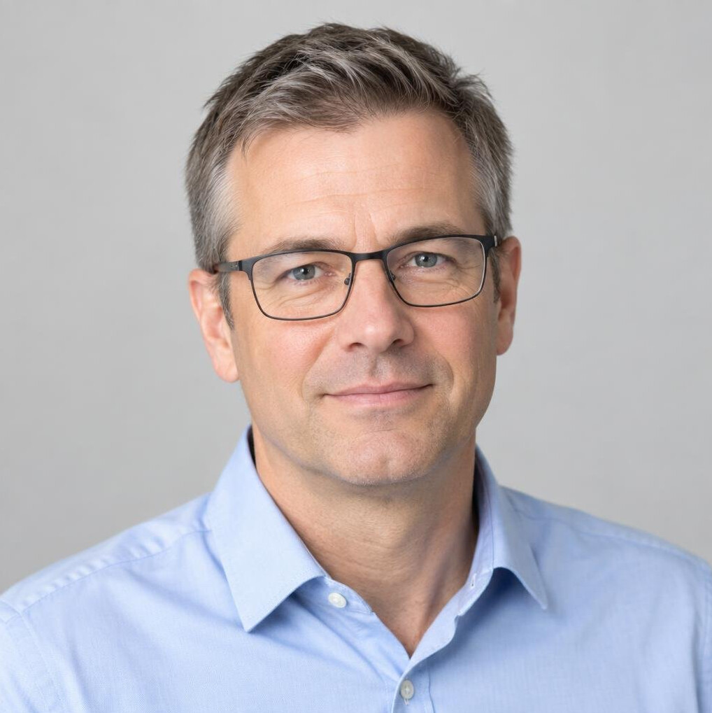 Portrait of a man with glasses and a light shirt